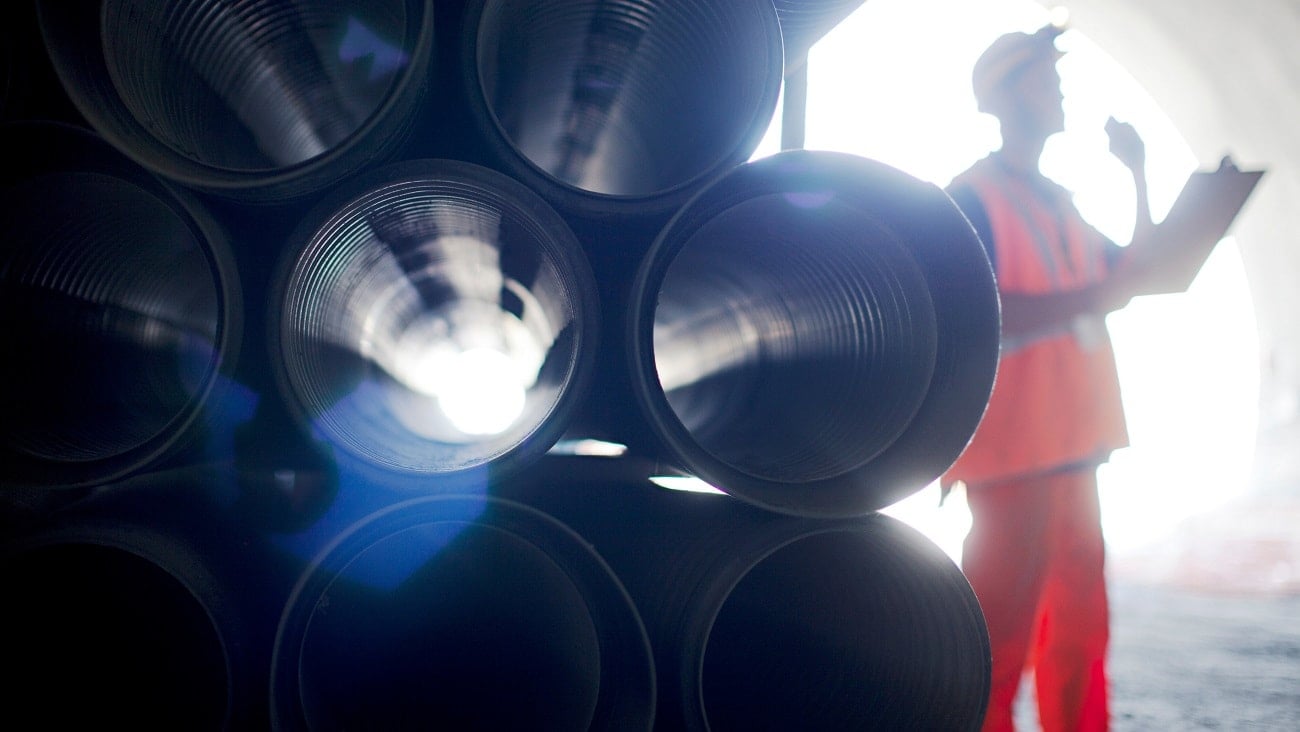 Man standing next to pipes