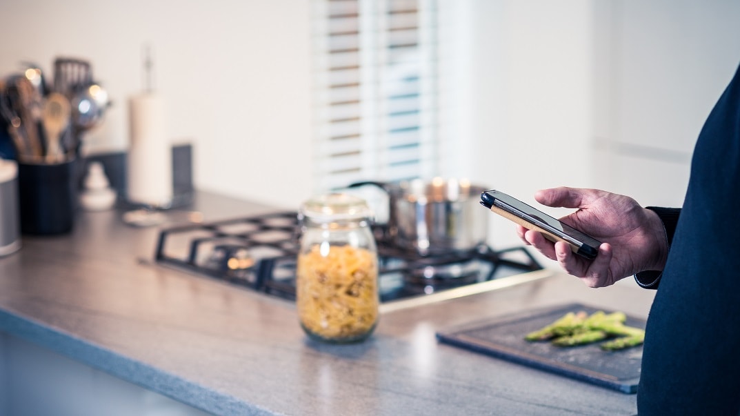 person holding phone in kitchen