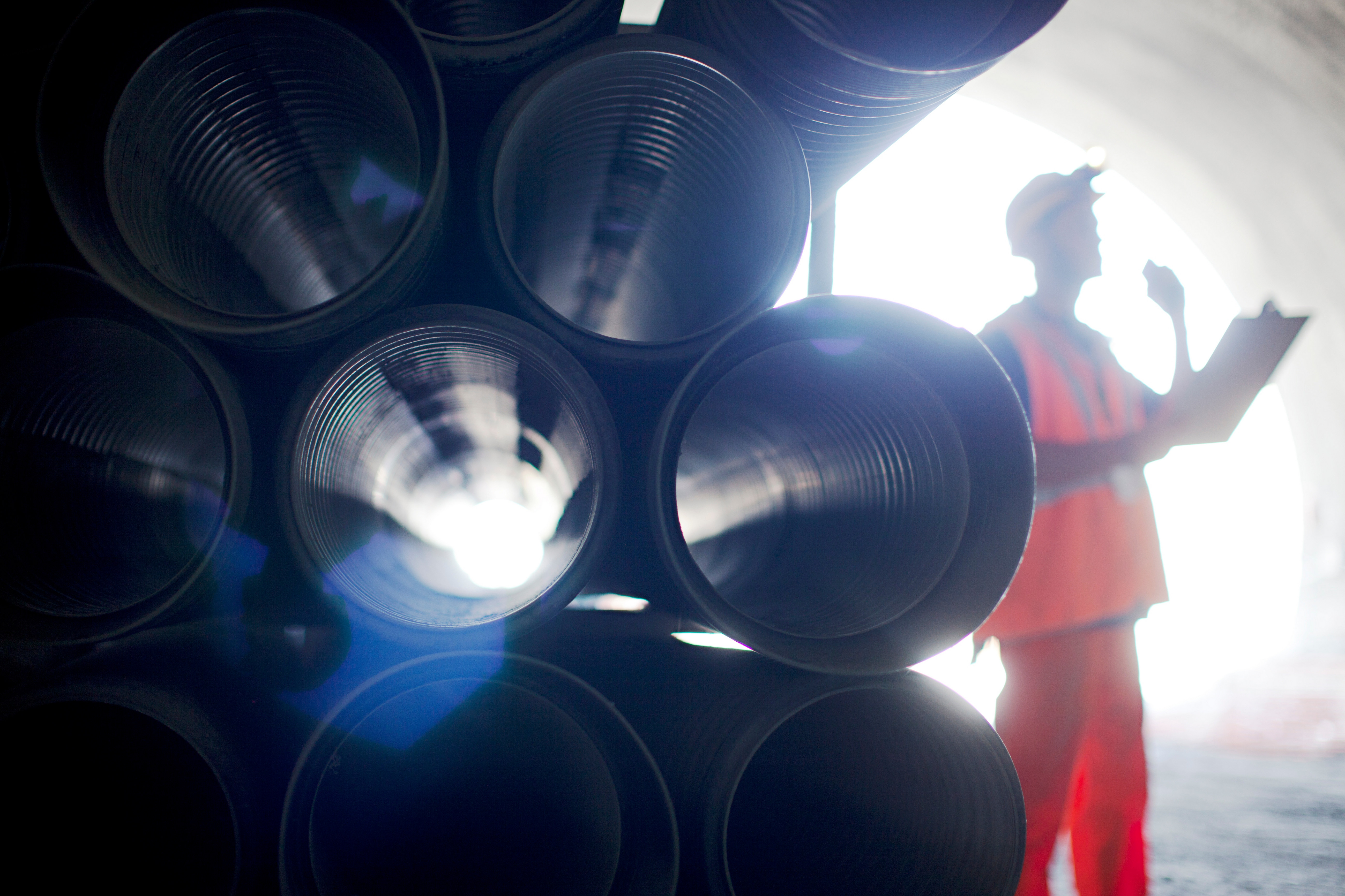 employee standing next to pipes