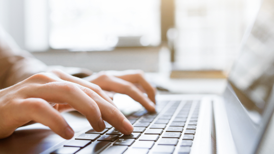 person typing on laptop keyboard