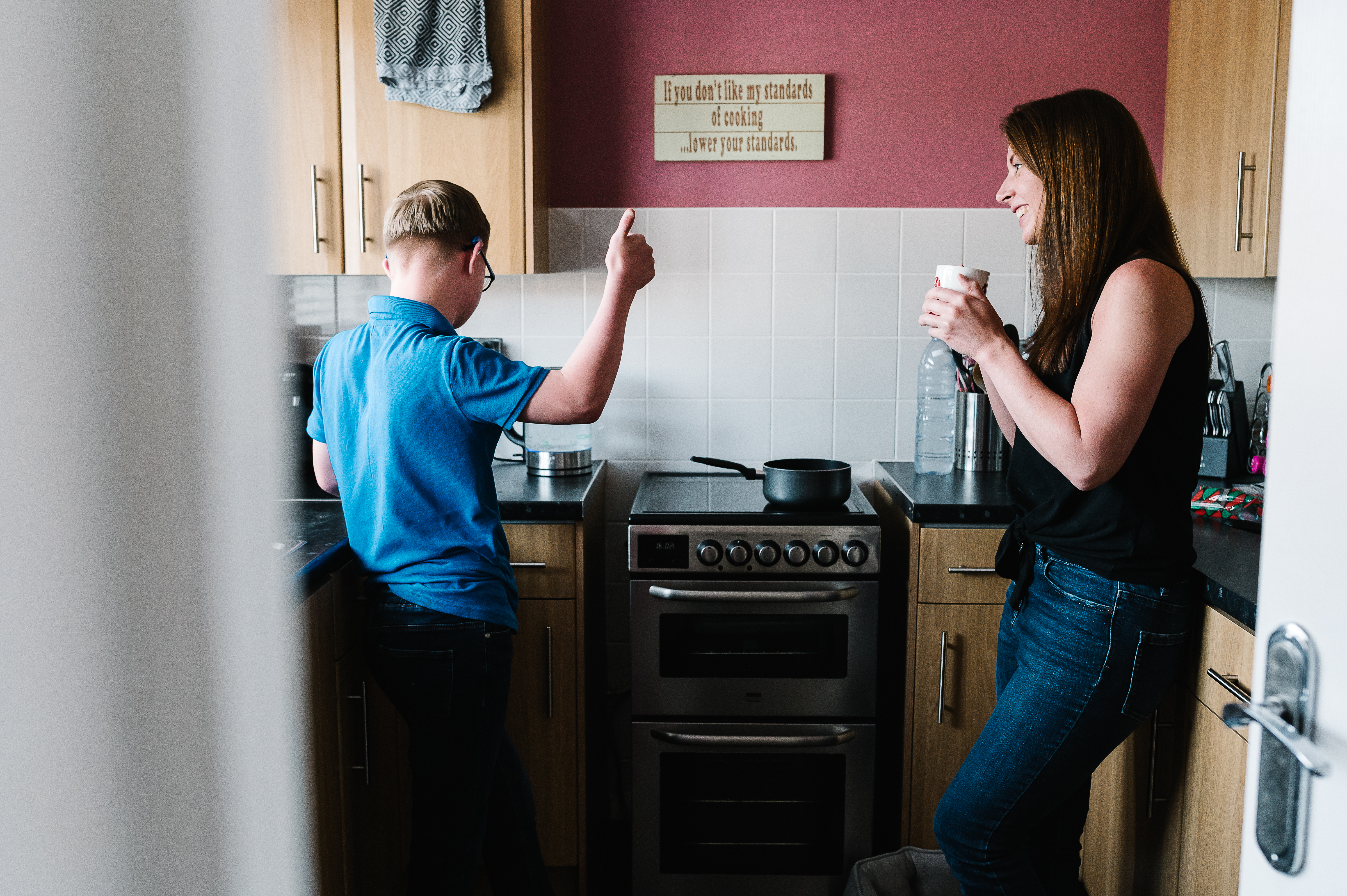 women and young boy in kitchen talking