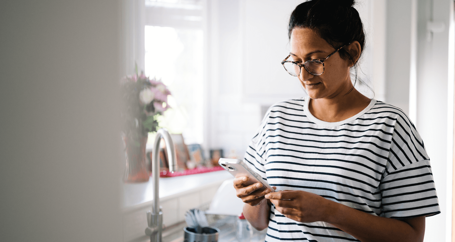 Lady in striped top on mobile phone in kitchen