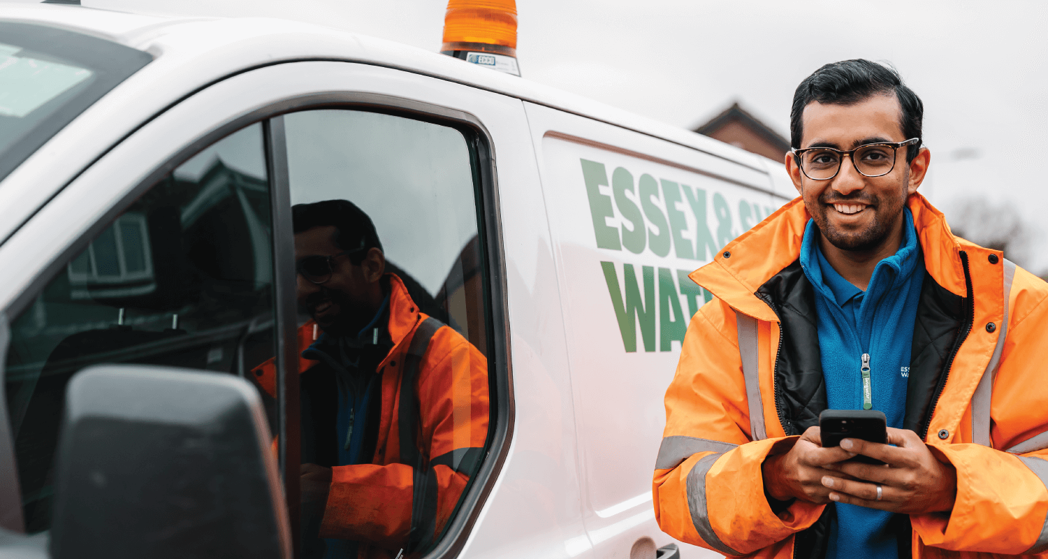 Essex & Suffolk Water employee in high-vis next to van