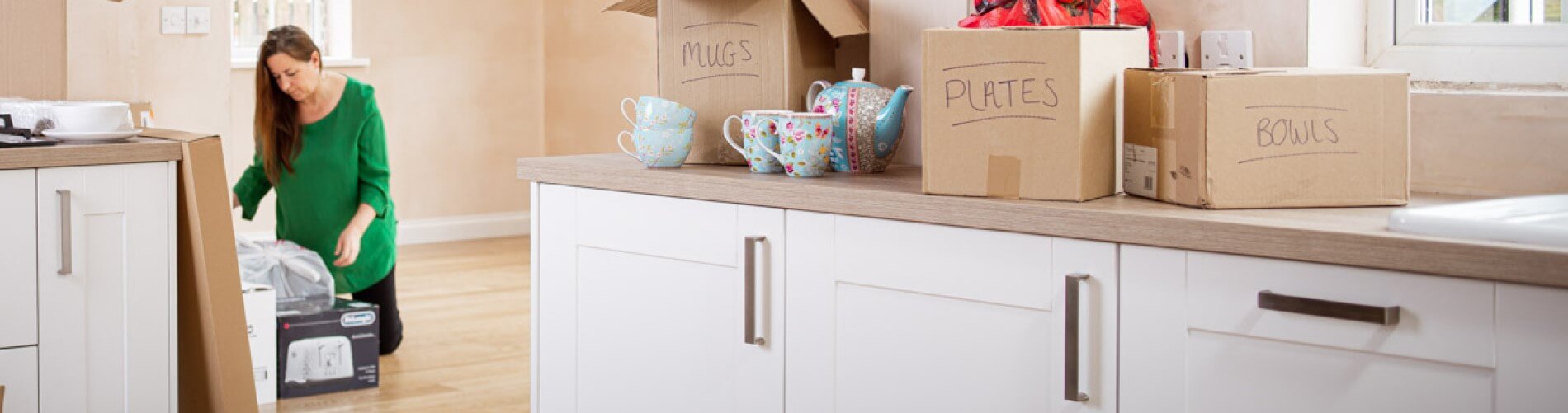 Woman unpacking boxes in kitchen