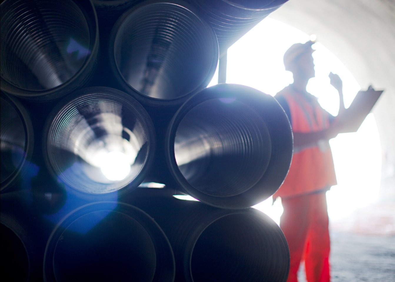 Man standing next to pipes